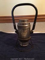 Front view of the railroad electric torch lantern showing the metal body, handle, and protective cage around the glass lens.