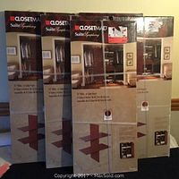 Five boxed ClosetMaid SuiteSymphony closet organizers stacked, showing cherry wood finish and cube insert layout.