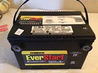 Front view of the black EverStart Maxx75R truck battery showing the label with branding, warranty and specifications.
