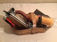 Photo showing lot of drywall equipment including drywall hawks, drywall trowels, and paint roller in a basket.