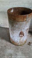 Full view of vintage metal milk can standing 31 inches high with rust and peeling paint, showing cylindrical shape and metal handle.