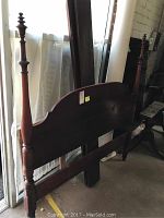 Photo of the bed frame showing the headboard with turned posts and one post with glue repair at the top