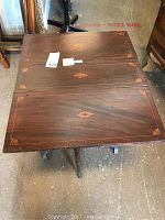 Top view of the wooden table with fold-down sides showing inlaid diamond designs on the surface.