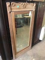 Full view of tall rectangular oak framed mirror standing upright showing entire frame and mirror surface.