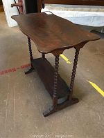 Full view of the mahogany veneered table showing top, legs, and floor level shelf