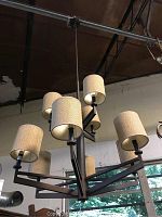 Full view of hanging light fixture with 9 fabric-shaded bulbs attached to metal arms.