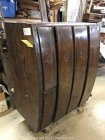 Three-quarter view of the curved front walnut chest showing five drawers and no hardware
