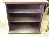 Front view showing walnut wooden hutch with two shelves inside and solid back panel.