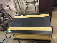 Table with black and natural wood finish, scratches visible on top surface