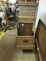 Wooden chest with top, wide side view showing inside and handle on the front.