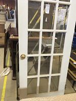White French door showing multiple glass panes and brass doorknob.