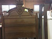 Full view of the wooden headboard and two side rails showing overall size and condition.