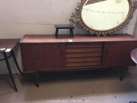 Overall view of teak buffet, showing sliding doors on each side and central column of five drawers