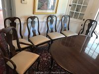 Group view of six chairs around a table on rug