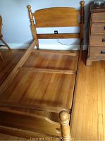 Full view of wooden twin bed frame showing frame, headboard, and footboard with turned post details.