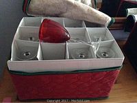 12 red wine glasses securely packed in a red quilted carrying case with dividers.