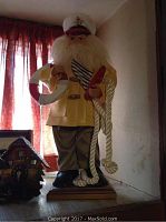 Sailor man figurine standing on a wooden base with realistic nautical attire, holding a rope and lifebuoy.