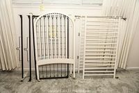 Photo showing all major crib components, including headboard, footboard, and side rails arranged upright against a curtain backdrop.