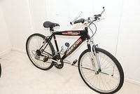 Side view of black Huffy Highlands mountain bike with 20-inch wheels and ASR suspension fork, showing frame and components.