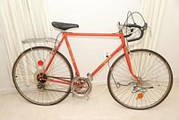 Full side view of orange Gitane Simplex 10-speed road bike with drop handlebars and rear luggage rack.