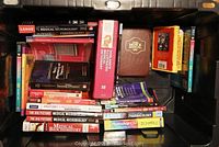 View of plastic tote filled with various medical and related textbooks.