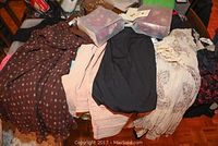 Lot items arranged to display various clothing pieces laid out with two boxes of Laura Ashley potpourri bags with tags on top.