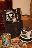 Photo showing new Elmer's Foam Display Board leaning against a chair, with metal foil trash can and Kik Step library step stool on carpet.