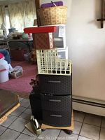 White plastic office storage unit with one drawer missing, basket and box on top