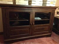Front view of credenza showing dark brown finish, two glass-paneled doors and wooden knobs