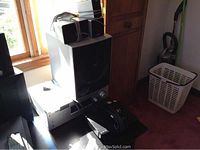 Sony black stereo receiver STR-K700 with front knobs and buttons viewed from front and sides, paired with Sony SS-SRP700 speakers stacked on top of box in daylight near window.