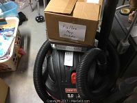 Photo showing Craftsman wet dry vacuum with hose and a box labeled 'Fuller Mop Heads' on top.