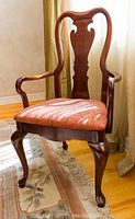 Full view of one cherry wood armchair with seat upholstery
