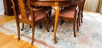 Full view of the table on a rug with chairs for scale