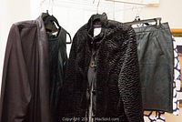 Photo of various women's clothing including textured fur jacket, leather skirt, and jacket with leather sleeves