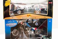 Photo showing Maisto Porsche Carrera GT model car and American Chopper model motorcycle in original packaging.
