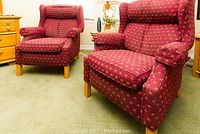 Two red patterned upholstered armchairs, wooden legs, visible cushion details.