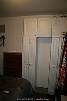 White storage cabinet and wood bookcase positioned side by side in room