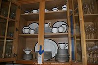 China set displayed on wooden cabinet shelves