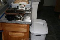 Photo showing mandoline slicer, seven baskets partially visible in background, displayed on countertop