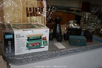 Photo showing boxed 10-piece Asian sushi set on countertop with additional items behind