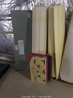 Stack of two yoga mats, two folded rugs, and a yoga kit book visible