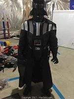 Photo of full-size Darth Vader costume with helmet, cape, and chest panel.