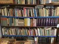 Books on shelves with a variety of theological, philosophy, and religious titles, mostly hardcover and some paperback, in used condition.