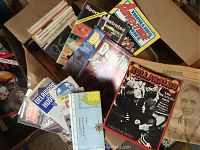 Box containing various vintage magazines and comics including Hullabaloo, Devilina, Thrilling Adventure, Sports Illustrated, and road maps. Visible wear seen on items.