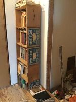 Tall wooden shelf filled with books and featuring the five wooden crates with Blue Flag Pears advertising on the sides.