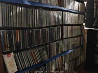 Wide view of multiple shelves filled with CDs, showing the quantity and storage method of the lot.