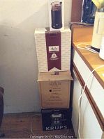 Stack of boxes including Melitta coffee cup box, Gevalia Kaffe box, and Krups espresso maker box.