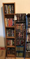 Wooden shelving unit with five shelves filled with assorted DVDs.