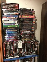 Three vertical stacks of DVD cases on shelving, showing overall lot
