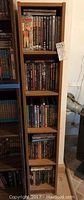 Tall 5-shelf storage unit filled with DVDs of various titles and genres.